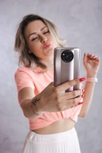 woman in peach crop top holding cellphone