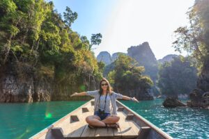 photo of woman sitting on boat spreading her arms
