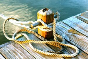 brown wooden dock with post tied with brown rope