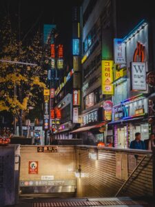 two person walking beside building at nighttime