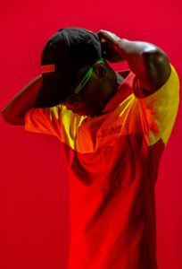 man dressed in dhl clothes posing in red lighting