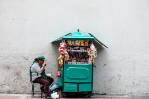 woman eating while seated next to mobile shop cart
