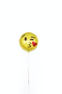 golden foil balloon with smiley kissing face and heart