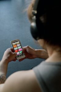 person with headphones holding a smartphone