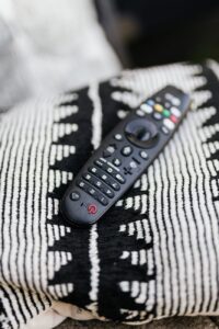 black remote control on white and black throw pillow