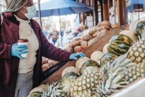 black woman choosing melon in street market