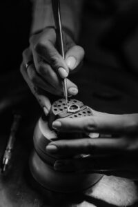 person holding a metal tool setting a jewelry