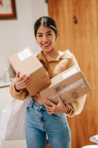 happy ethnic female with parcels at home