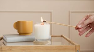 a hand lightning the scented candles on the table