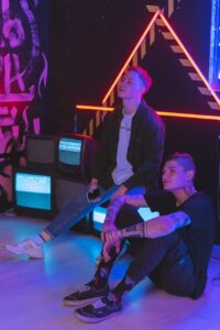 men sitting beside old televisions