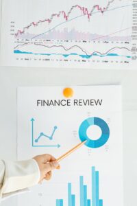 person holding a pencil showing finance review chart