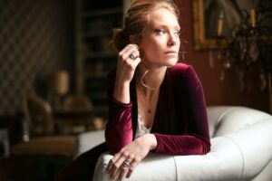 selective focus photo of a woman sitting on white leather sofa