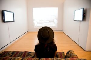woman sitting on red and green suede sofa facing well lighted room