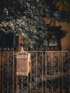 brown mailbox on brown metal gate