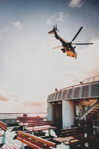helicopter flying over ship deck at sundown