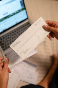a person s hand holding a cheque