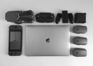 silver macbook surrounding black electronic devices