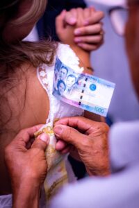 elderly person hands pinning philippine pesos to clothes