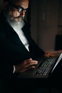 photo of an oid man using laptop