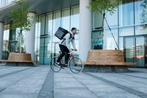 woman in white long sleeve shirt and blue denim jeans riding on black city bike during