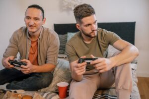 men sitting on the bed while playing video game