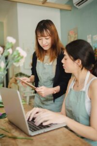 focused multiracial florists browsing laptop in workspace
